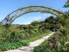 Arches couvertes de grimpantes avec en point de fuite la maison de Claude Monet Arches couvertes de grimpantes avec en point de fuite la maison de Claude Monet